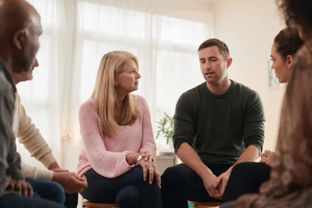 Man speaking during support group therapy session at San Diego Wellness Center.
