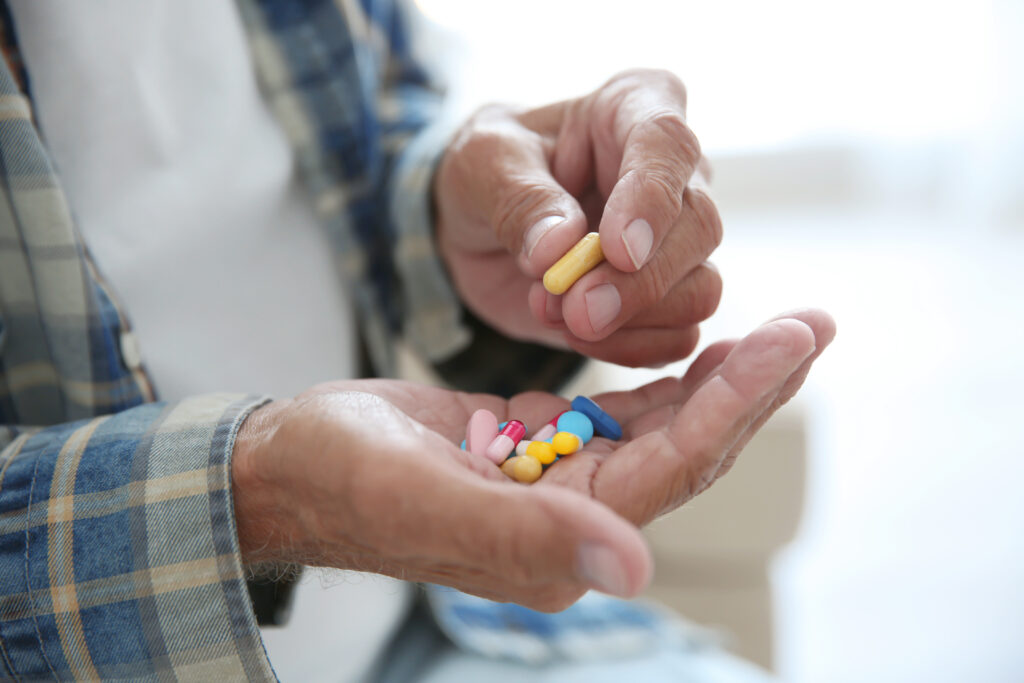 Person holding prescription pills, representing medication-assisted treatment (MAT) for prescription drug addiction recovery.
