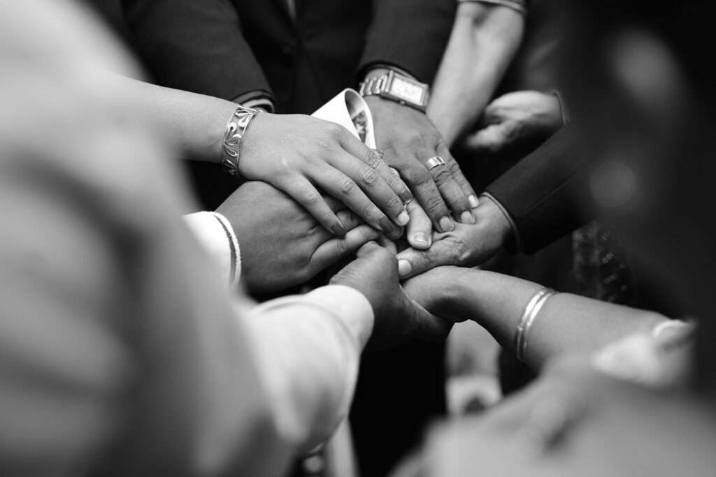 hands holding, stacked on top of each other in black and white. Addiction Treatment at San Diego Wellness Center