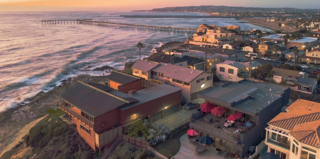 Houses on the waterfront of a beach with a sunset. Addiction Treatment at San Diego Wellness Center.