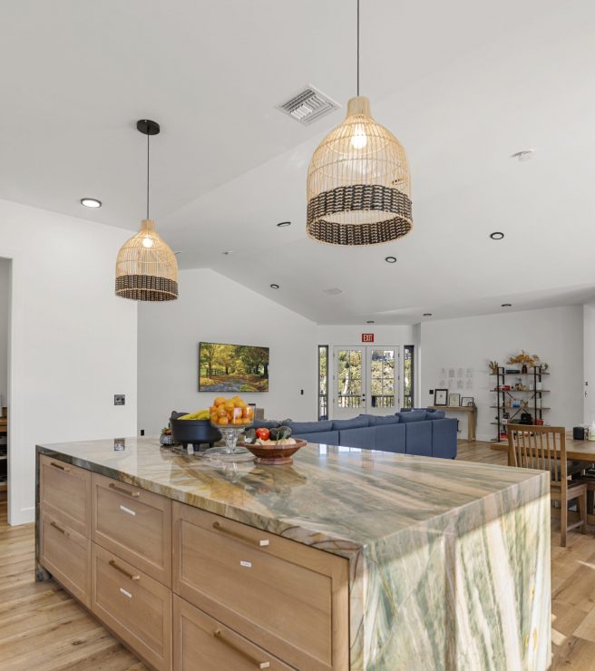 Beautifully spacious Kitchen and Dinning area of the SD-Wellness Drug Rehab Facility in Ironwood, CA. Luxurious marble counter tops and boho lampshades. High ceiling, white walls, and Woodend floors with a blue couch